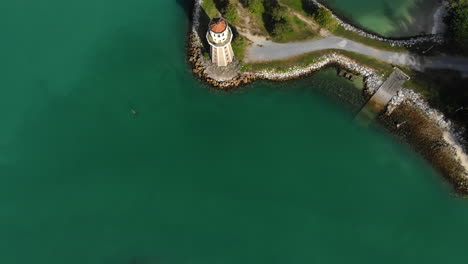 Luftaufnahme-Von-Oben-Nach-Unten-über-Einen-Leuchtturm-Mit-Türkisfarbenem-Meer-Und-Ankernden-Booten