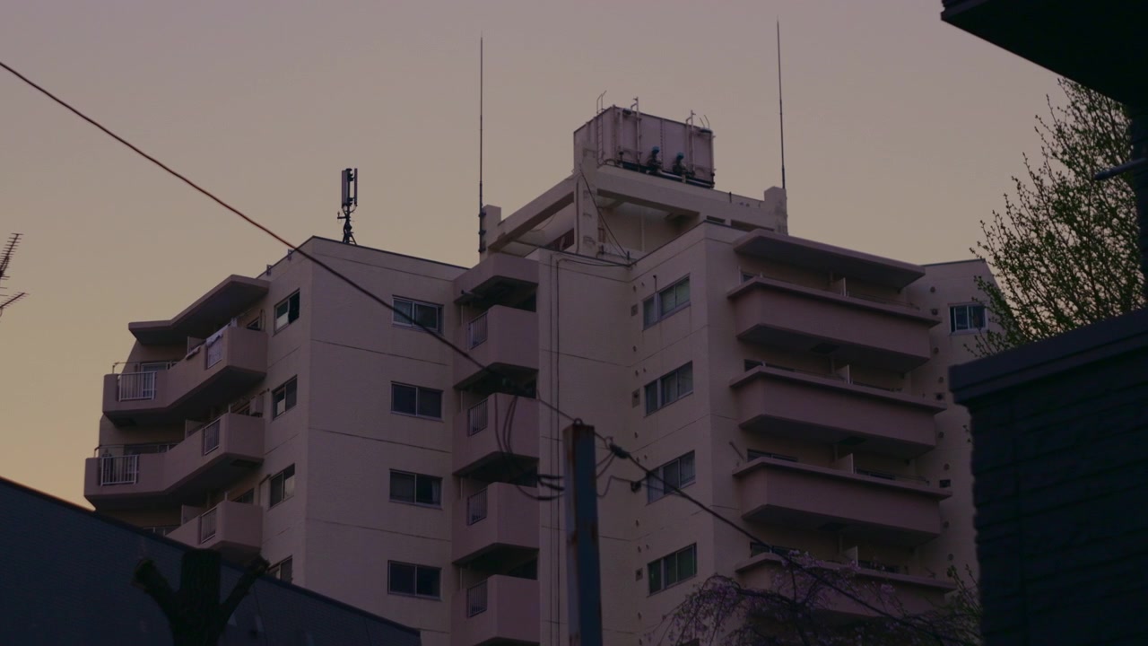 Vista de rua local em Tóquio com edifícios residenciais e ambiente urbano.