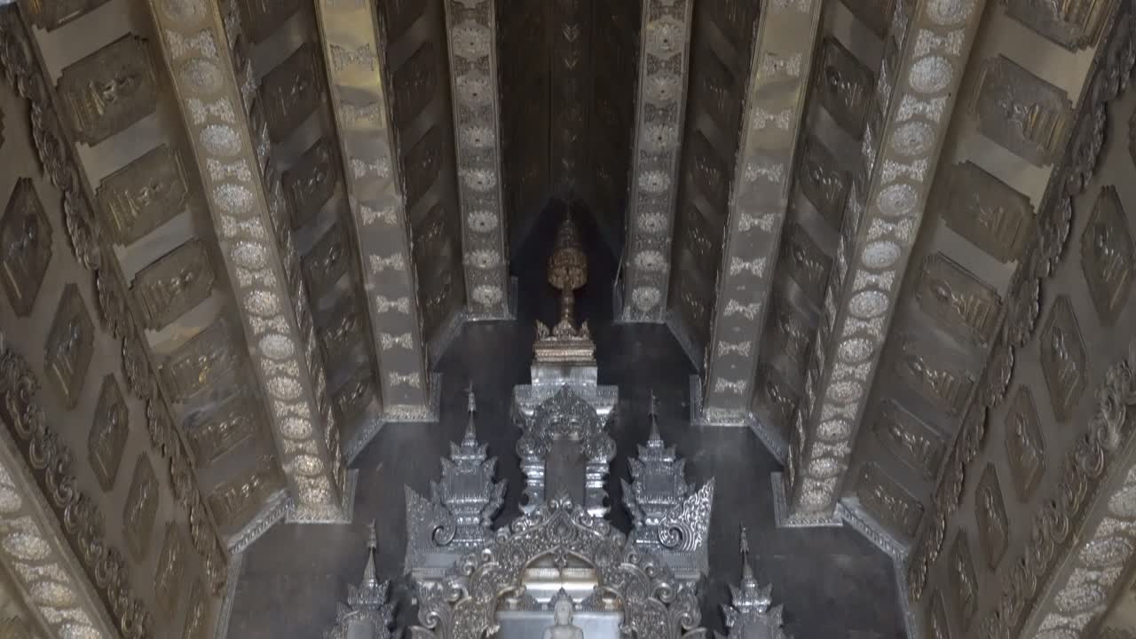 Thailand,Chiang Mai,Tilt down slowly from ceiling towards the Golden Buddha Statue,closer look, inside the Famous Silver Temple,Wat Si Supan.