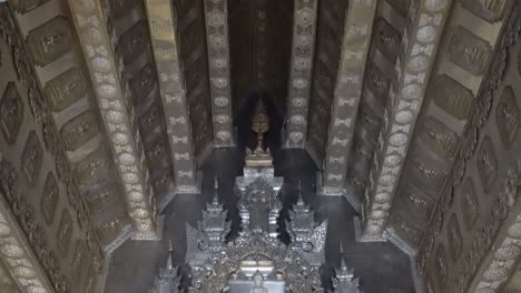 thailand,chiang mai,tilt down slowly from ceiling towards the golden buddha statue,closer look, inside the famous silver temple,wat si supan.