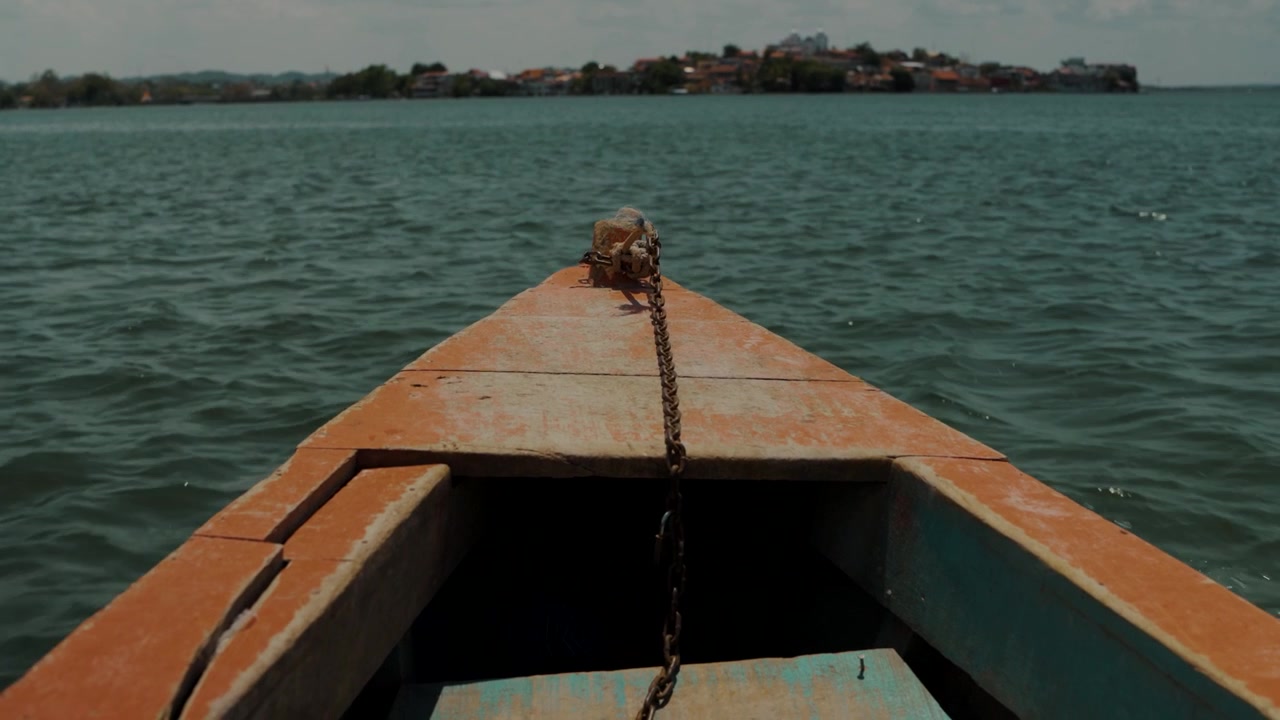 Barca di legno che attraversa il lago verso una città insulare a Peten, Guatemala.