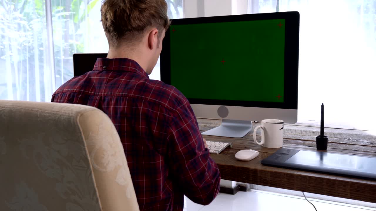 Behide of freelancer programmer male typing on wireless keyboard