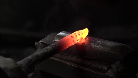 the blacksmith strikes hot metal with a hammer