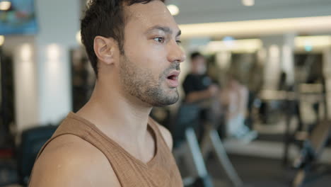 Portrait-Of-Fit-Man-Running-On-Treadmill-In-Gym-and-Breathing-Heavily