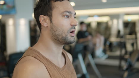 Retrato-De-Un-Hombre-En-Forma-Corriendo-En-Una-Caminadora-En-El-Gimnasio-Y-Respirando-Pesadamente