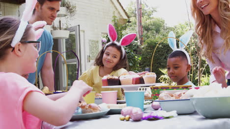 Padres-Con-Niños-Con-Orejas-De-Conejo-Disfrutando-De-La-Fiesta-De-Pascua-Al-Aire-Libre-En-El-Jardín-De-Casa