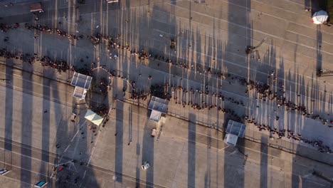 Luftdrohne-Von-Oben-Nach-Unten-Pov-über-Eine-Lange-Schlange-Von-Menschen,-Die-Bei-Sonnenuntergang-In-Buenos-Aires-Warten