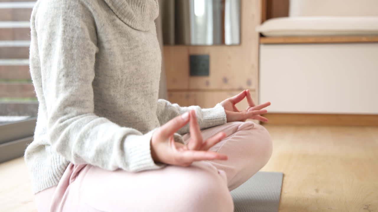 Woman meditating on yoga mat at home, practicing mindfulness and relaxation, copy space