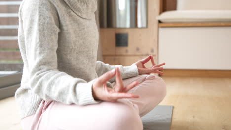 woman meditating on yoga mat at home, practicing mindfulness and relaxation, copy space