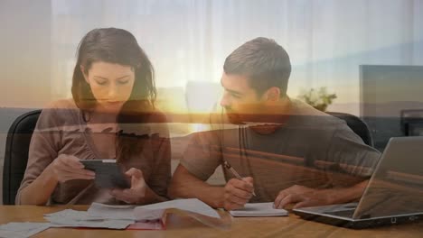 Animation-of-a-Caucasian-couple-reading-papers-over-a-sunset-on-a-beach