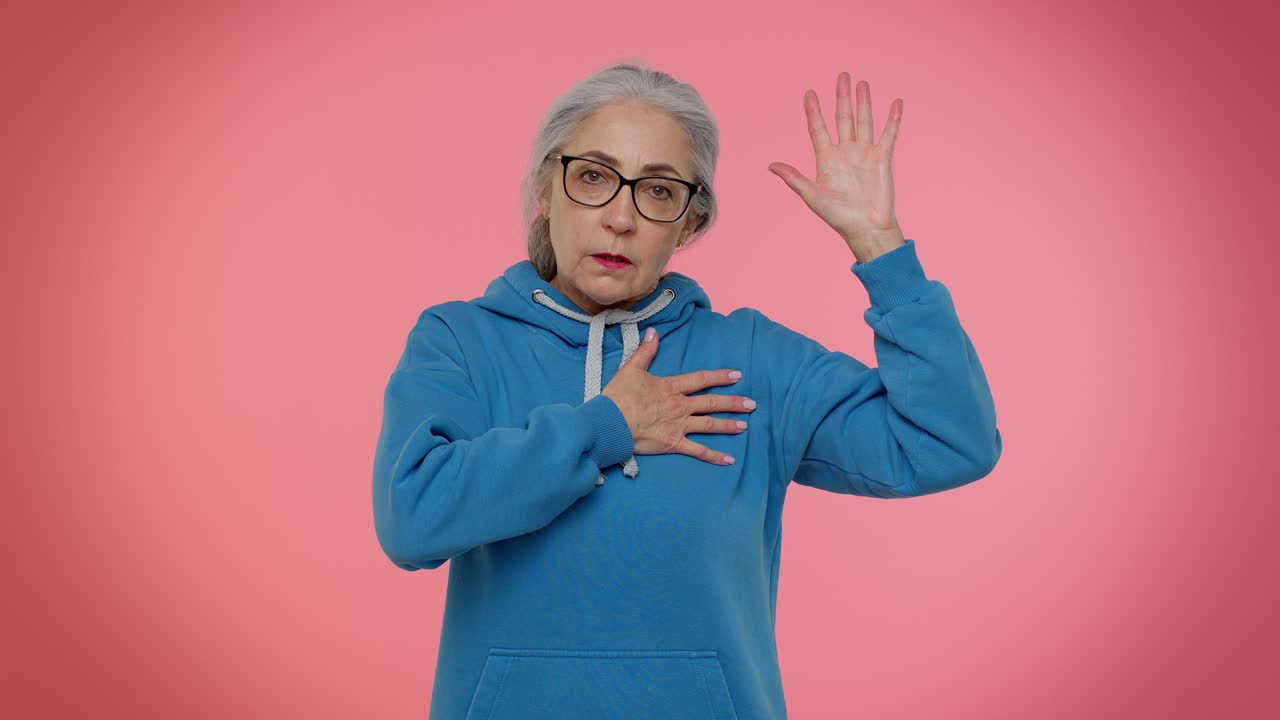 Sincere responsible senior grandmother woman swear to be honest tell truth raising hand to take oath