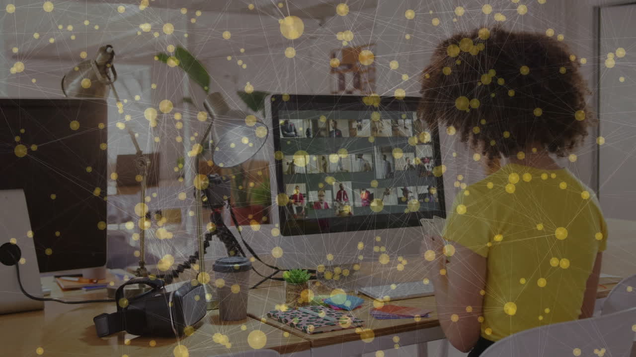 Person working at desk with network connections animation over computer screen