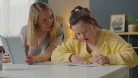 girl with down syndrome doing assignment with help of teacher