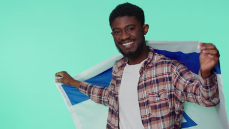 Man-waving-and-wrapping-in-Israel-national-flag,-celebrating-Independence-day-on-gray-background