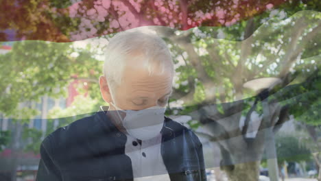 animation of flag of netherlands waving over caucasian man wearing face mask in city street