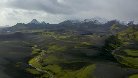 Ein-Drohnenvideo-Aus-Dem-Südisländischen-Hochland,-Das-Schwarzen-Sand,-Grünes-Moos-Und-Schnee-In-Den-Bergen-Zeigt