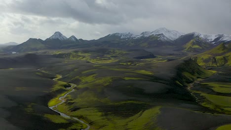un video de drones de las tierras altas del sur de islandia que muestra arenas negras, musgo verde y nieve en las montañas