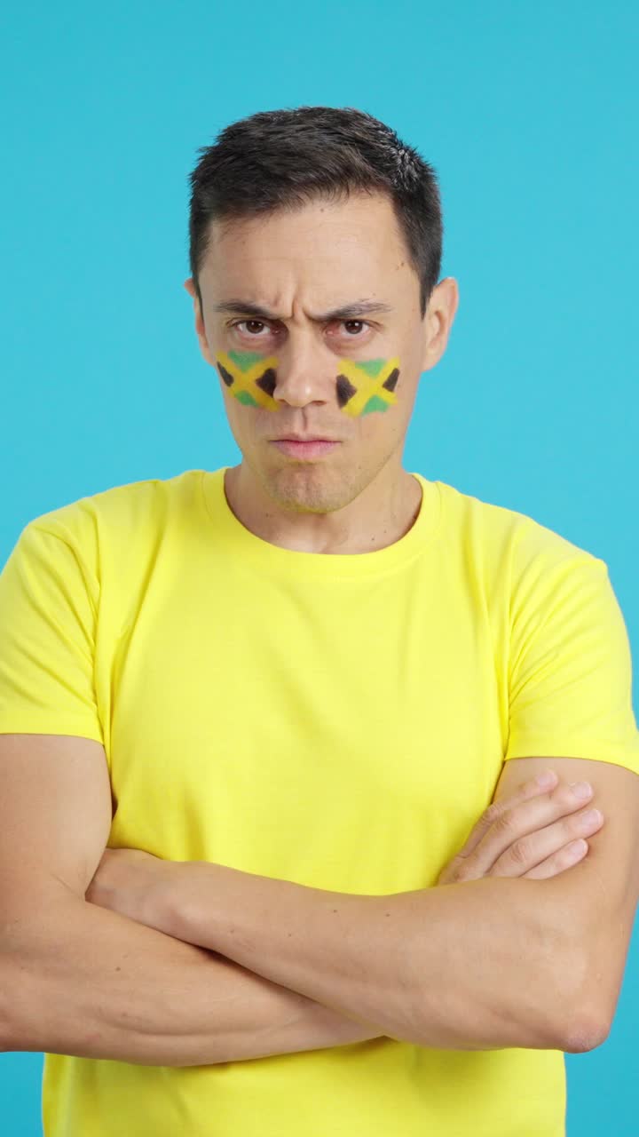Dignified and serious man with jamaican flag painted on face