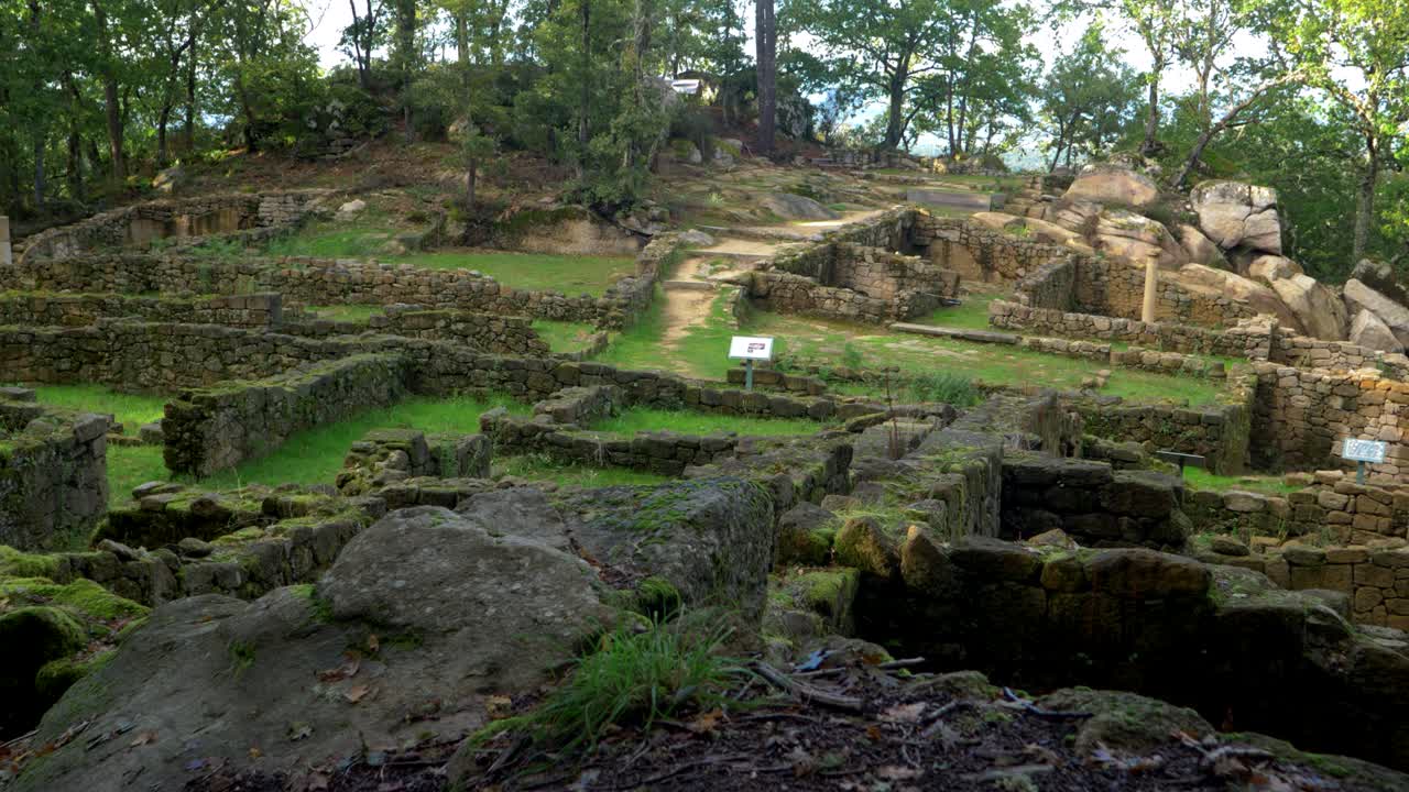 Stone ruins at Castro Cibdá de Armeá archaeological complex, surrounded by trees, Ourense, Galicia