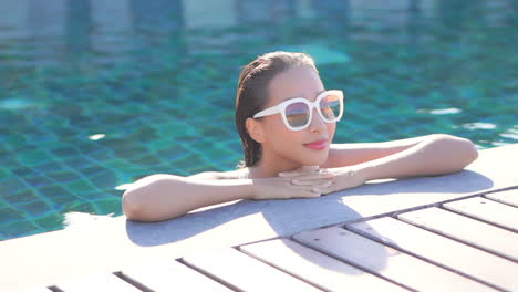 close-up of beautiful asian woman with sunglasses in pool