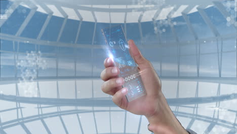 hand holding futuristic mobile phone against digitally generated background