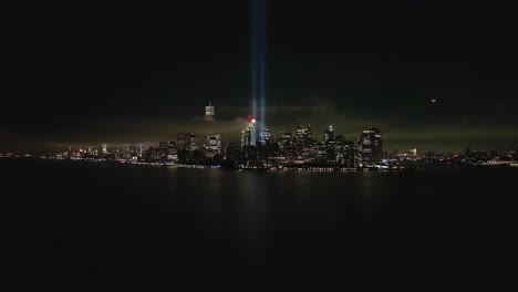 An-aerial-view-of-the-Freedom-Tower-in-the-financial-district-in-New-York-City-at-night,-with-the-tribute-in-light-twin-beams-illuminated