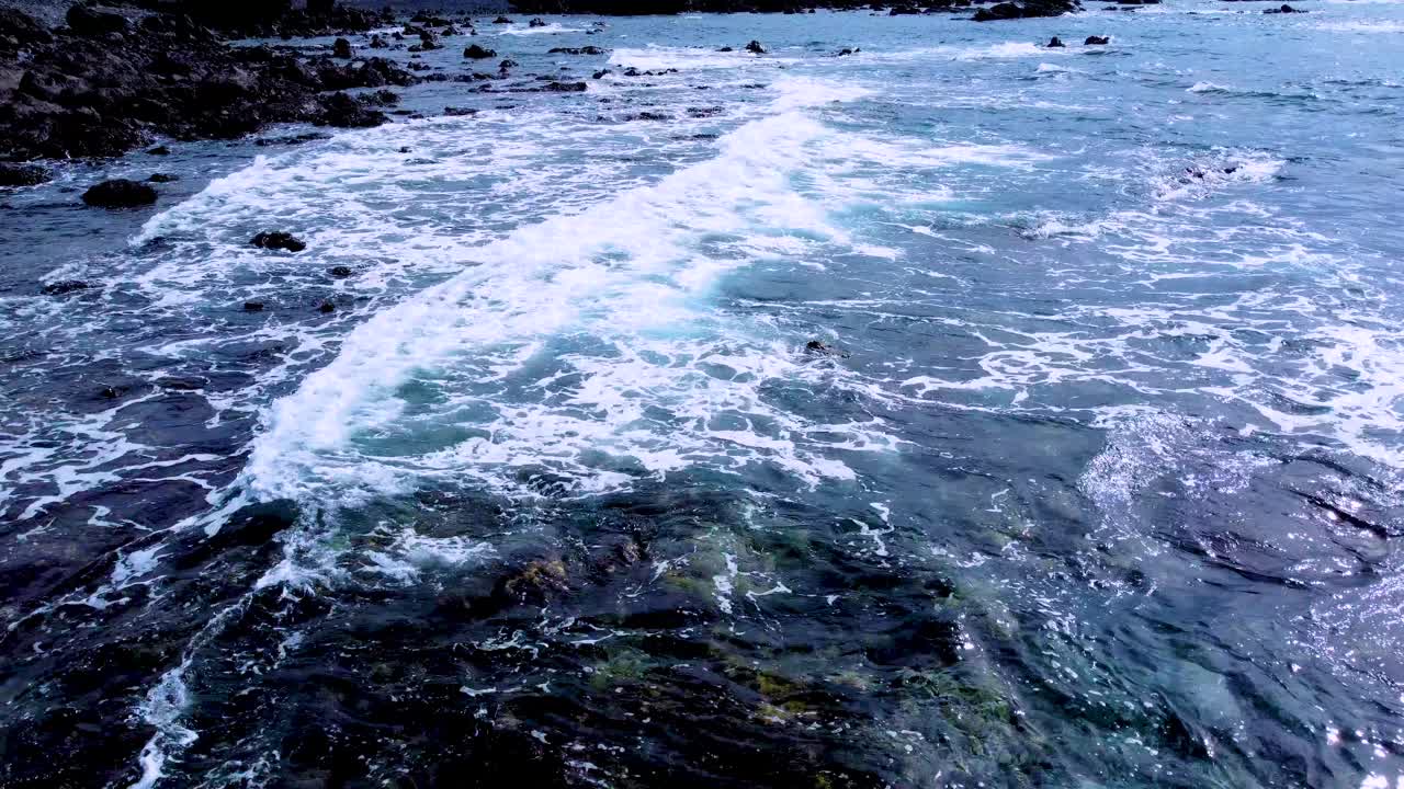 Uma costa rochosa com ondas do oceano quebrando perto de Punta Blanca em Tenerife, Espanha