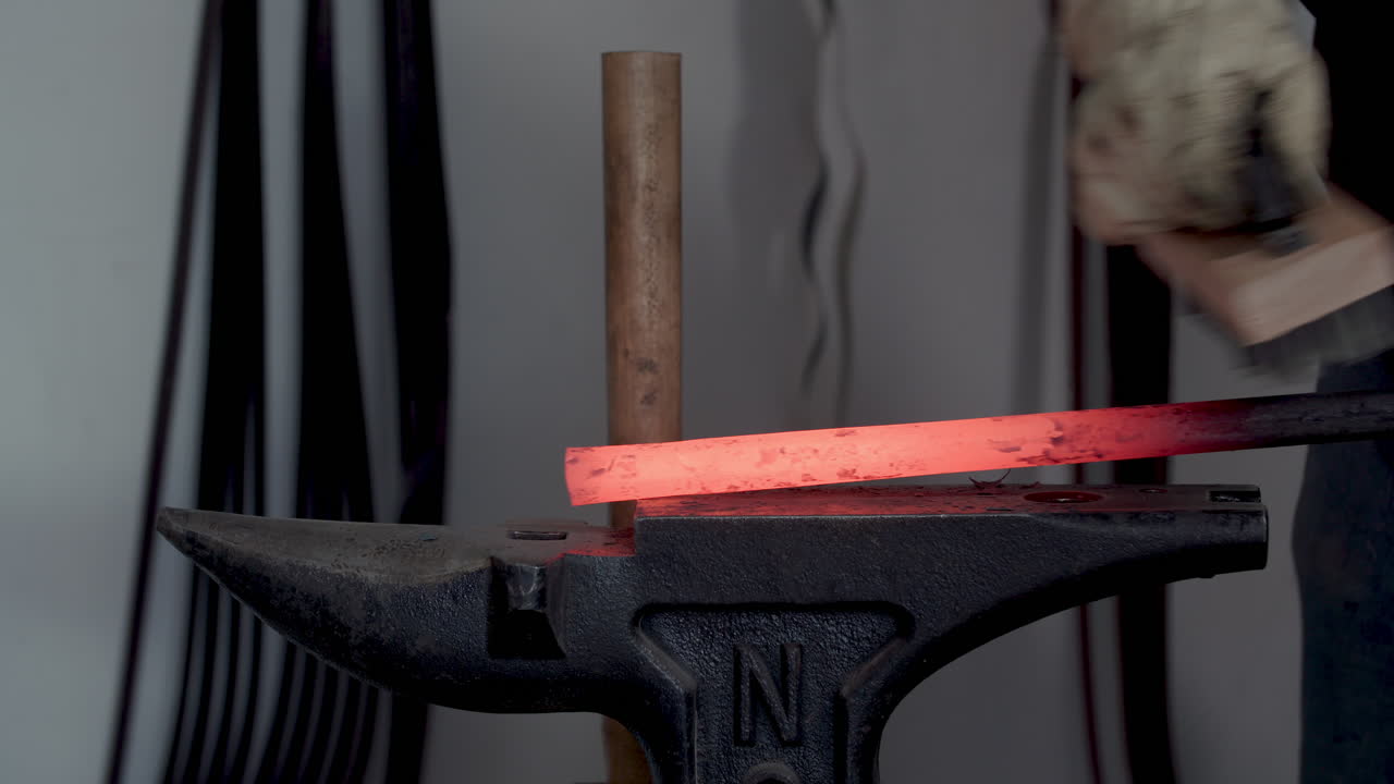 cepillado de metal al rojo vivo en el yunque del herrero