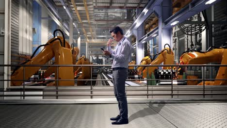 full body side view of an asian male professional worker standing with his phone with industrial robotic arms working, he is nodding his head with dissapionted