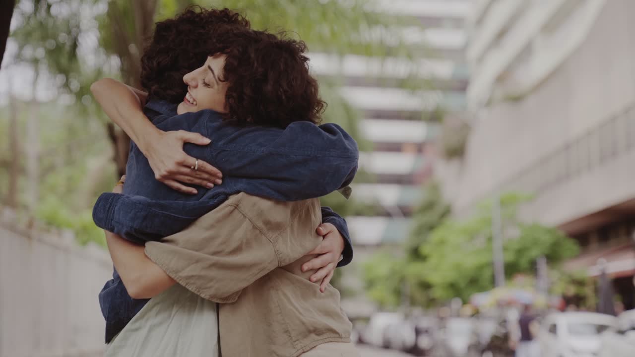 Two friends greeting and hugging with warmth on a city street