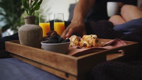 breakfast in bed reaching for scone on tray