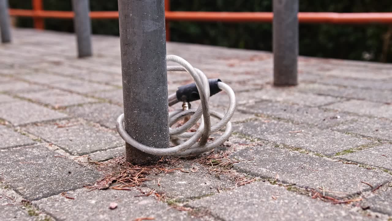 Stolen Bicycle Broken Lock Cable Attached to Metal Bike Stand Pole