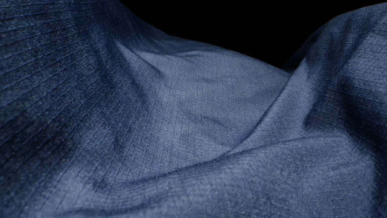 Waterproof clothing for tourism. Blue cloth texture with water drop close-up macro. Repellent waterproof breathable fabrics. Innovation waterproofing material test. High quality 4k footage