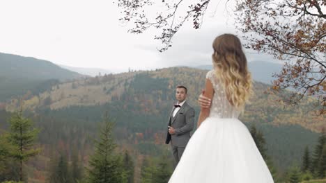 Lovely-caucasian-wedding-couple-newlyweds-family-bride-groom-stay-together-on-mountain-slope-hill