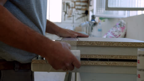 hombre profesional de bricolaje envolviendo piezas de madera de un