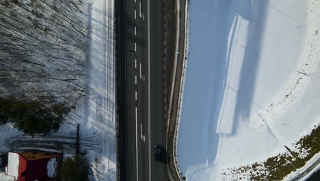 asphalt highway against snowy field on a sunny day