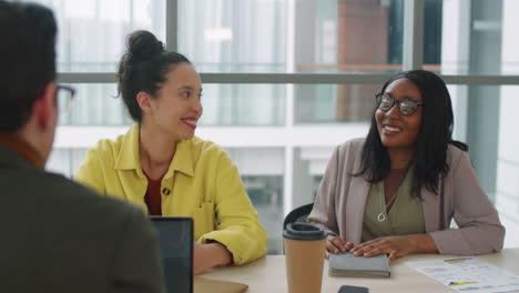 multiethnic coworkers speaking at business meeting