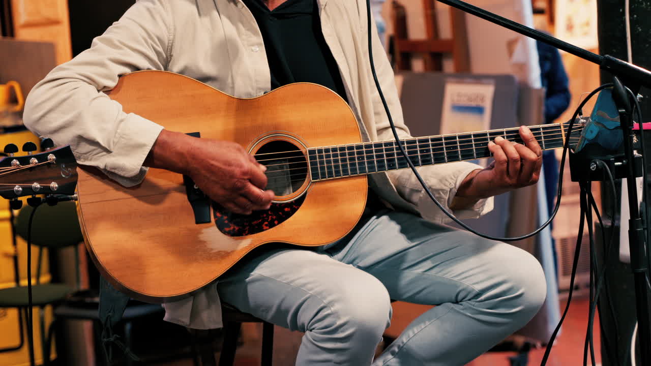 Close up of a man playing guitar and singing on the microphone