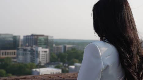 young urban businesswoman overlooking the city view cityscape on rooftop balcony