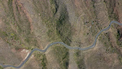 Drone-top-shot-of-cars-driving-on-a-road-in-the-mountains