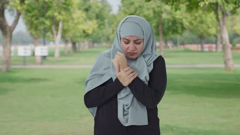 sick muslim woman suffering from arthritis in park