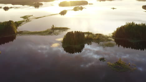 drone point of interest shot circling around uninhabited small islands on a calm lake by sunset golden hour