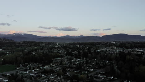 puesta de sol sobre las montañas de la ciudad suburbana en la columbia británica