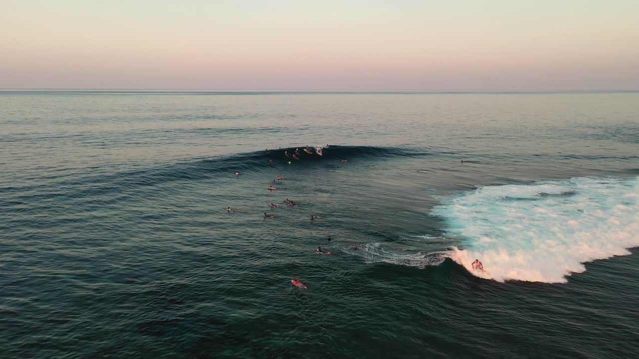 Veduta aerea di surfisti sulle onde in un'area di surf al tramonto, Isola di Siargao, Cloud 9, Filippine