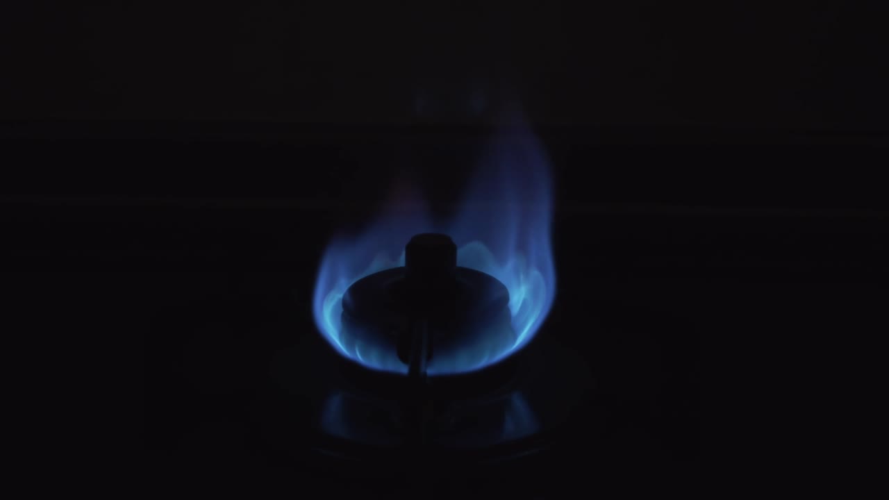 Lighted gas stove in the kitchen.