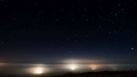 starry night sky above foggy city lights