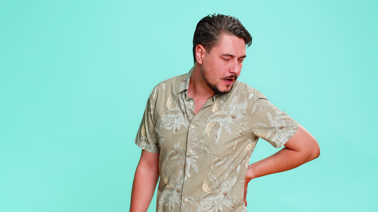 Man grimacing in pain holding lower back suffering from discomfort after long sitting work posture