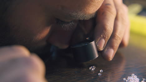 jeweler-looks-at-gems-with-magnifier-glass-extreme-closeup