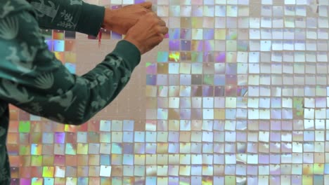 el hombre diseña un telón de fondo de azulejos cuadrados brillantes opalescentes para decoraciones