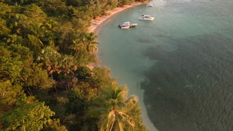 Drone-Volador-Sobre-Botes-En-La-Playa-Durante-El-Atardecer